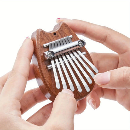 Mini kalimba en bois tenue à la main, instrument de musique Sonora-Mundi, lames numérotées.