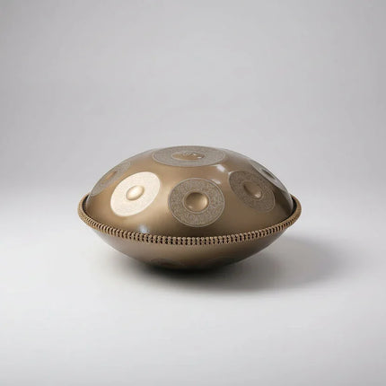 Handpan métallique artisanal Sonora-Mundi sur fond blanc, instrument de musique percussif.