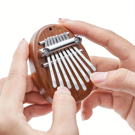 Petite kalimba en bois Sonora-Mundi, jouée à la main, sur fond blanc.