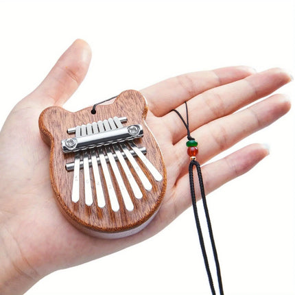 Mini kalimba en bois forme d’ours, instrument africain Sonora-Mundi tenu en main