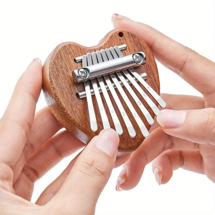 Kalimba en bois en forme de cœur tenue en main, instrument de musique Sonora-Mundi