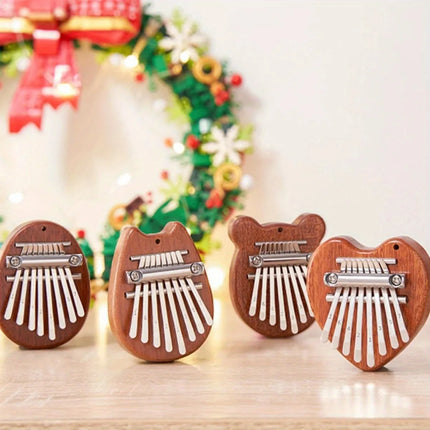 Quatre kalimbas en bois forme animal et cœur sur table, décor de Noël en arrière-plan, Sonora-Mundi