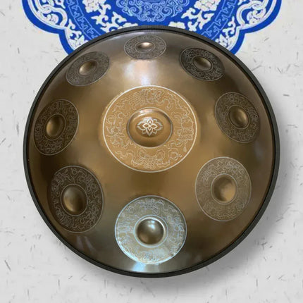 Handpan décoré motifs gravés, instrument de musique Sonora-Mundi sur fond mural bleu